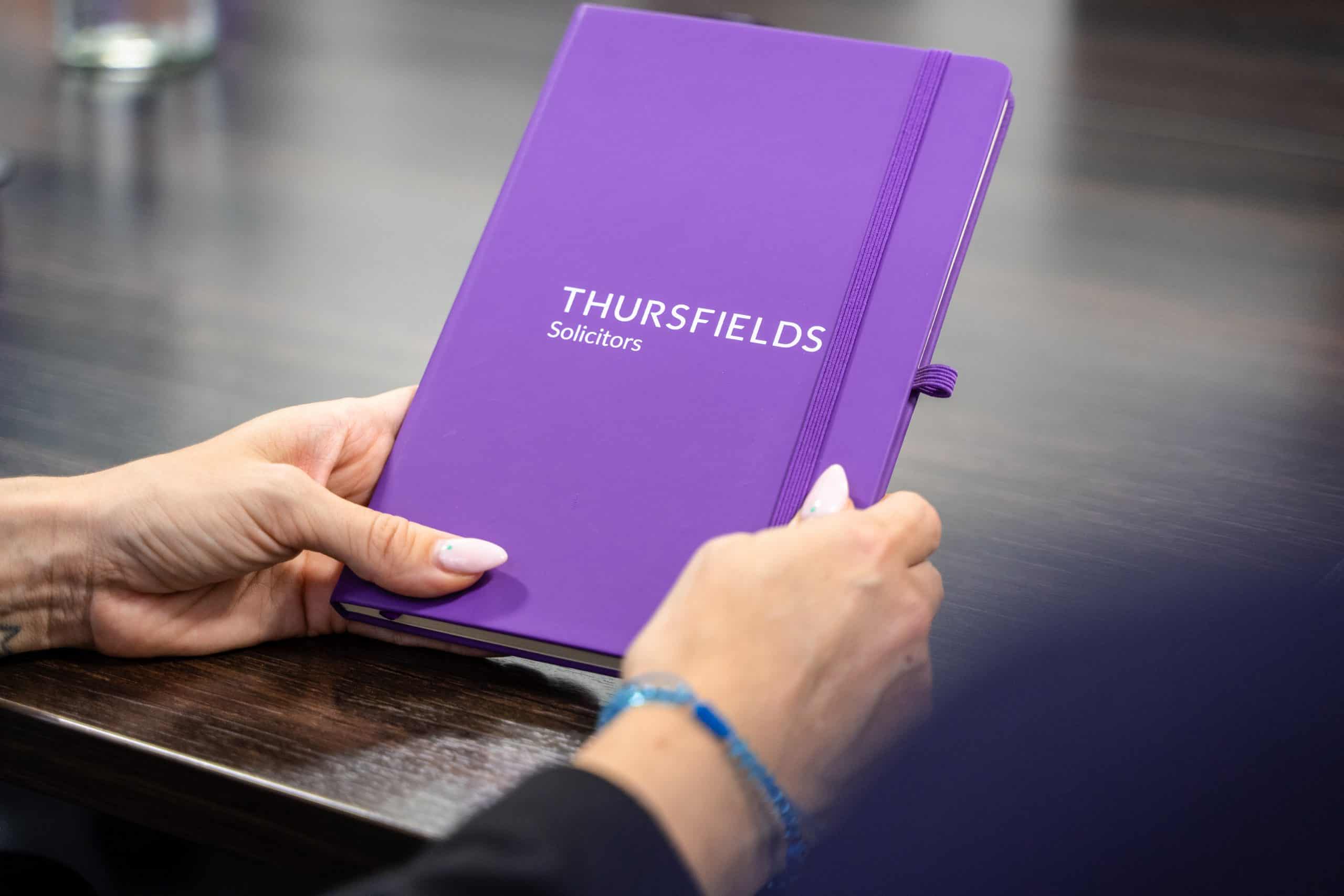 Regulatory - Thursfields notebook in hand