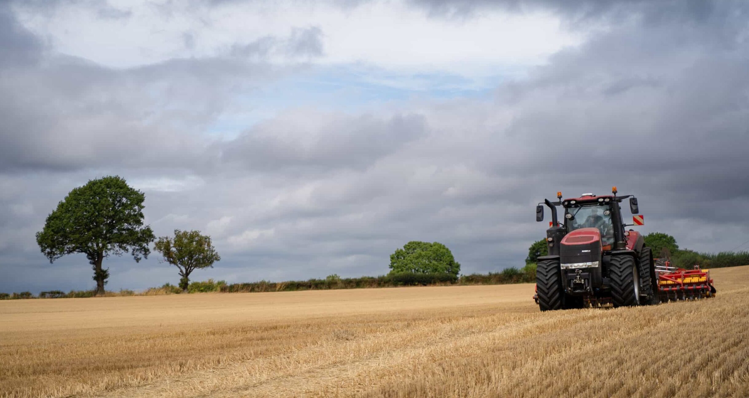 Agriculture - tractor in field with grey sky